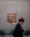 man walks past a graphic hermes facade man walks past a graphic hermes facade