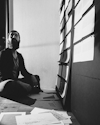 Monochrome photograph of a bearded man seated on the floor, looking thoughtfully at a board filled with papers in a sunlit room, symbolizing reflection during the user experience design process. Monochrome photograph of a bearded man seated on the floor, looking thoughtfully at a board filled with papers in a sunlit room, symbolizing reflection during the user experience design process.